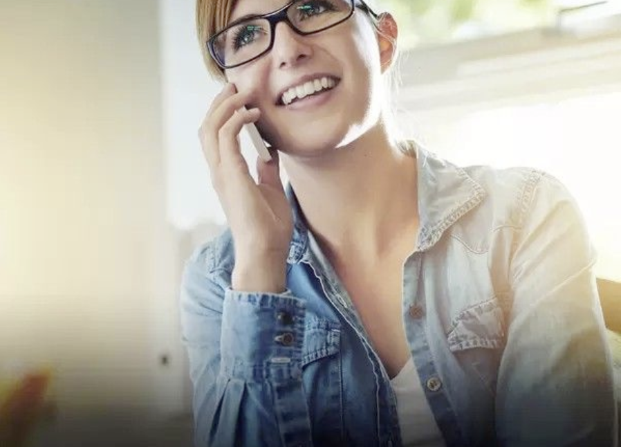 A woman in glasses talking on the phone.